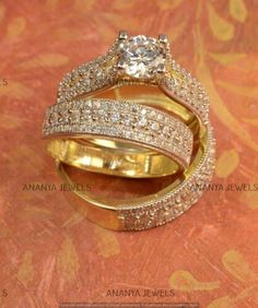 two gold wedding rings with diamonds on top and bottom, sitting next to each other