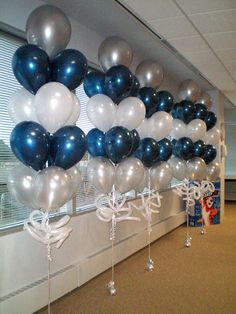 a bunch of balloons that are hanging from the side of a wall in an office