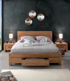 a bed with two mirrors on the wall above it and another table next to it