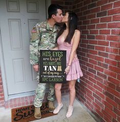 a man and woman are kissing in front of a sign that says, his eyes are almost as high as they can be