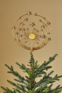 a small christmas tree with gold stars on it's top and a star decoration in the middle