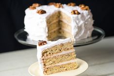 a slice of cake on a plate with the rest of the cake in the background