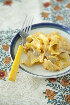 a white plate topped with pasta next to a fork