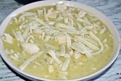 a bowl of chicken noodle soup on a table