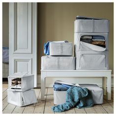 several storage containers stacked on top of each other in a room with wood floors and white walls