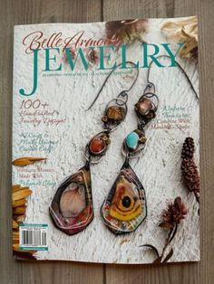 a magazine with some jewelry on it's cover, sitting on a wooden table