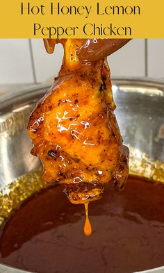 honey lemon pepper chicken is being lifted from a pot with sauce on it and the words, hot honey lemon pepper chicken