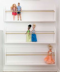 there are three barbie dolls on the shelves