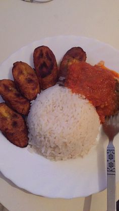 a white plate topped with rice and meat