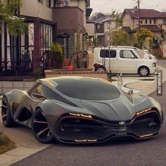 a futuristic car is parked on the street in front of some houses and a van