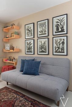 a living room filled with furniture and framed pictures on the wall above it's couch