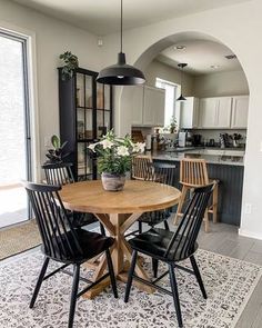 a dining room table with chairs and a potted plant sitting on top of it