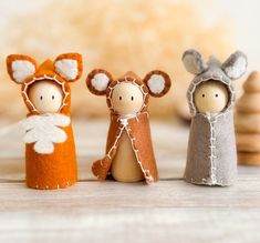 three small wooden dolls are standing next to each other