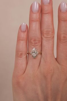 a woman's hand with a ring on it and a diamond in the middle