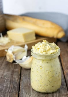 a jar filled with vegan garlic butter on top of a wooden table