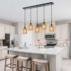 a kitchen with an island and four stools next to the counter top in front of two ovens