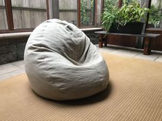 a bean bag chair sitting on top of a rug in a room with large windows