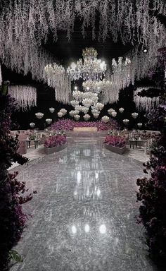 the inside of a building with chandeliers hanging from it's ceiling and flowers all around