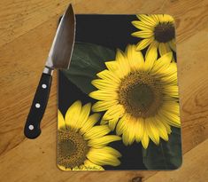 a knife and some yellow sunflowers on a table