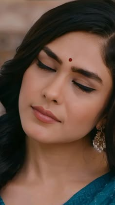 a woman with her eyes closed wearing earrings