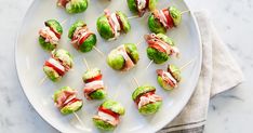 brussel sprouts wrapped in bacon and lettuce on a white plate