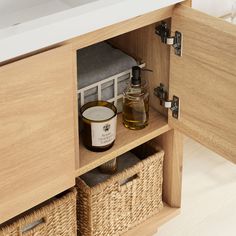 an open cabinet with two baskets and a soap dispenser on it's shelf