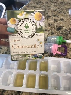 someone holding up a carton of chamomile in front of some toothbrushes