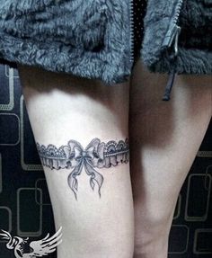 a woman's leg with a bow tattoo on it