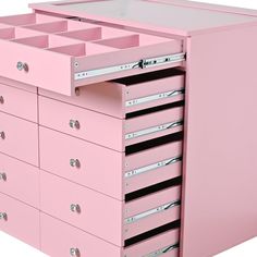 a pink dresser with many drawers and metal pulls on the bottom drawer, which is open to reveal several compartments