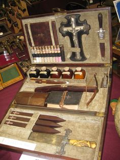 an old wooden box filled with tools and other items in it's contents, including knives