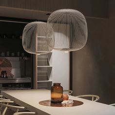 a table with chairs and a vase on top of it in a room that has an open kitchen