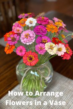 a vase filled with colorful flowers sitting on top of a table next to a napkin