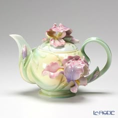 a tea pot with flowers painted on it