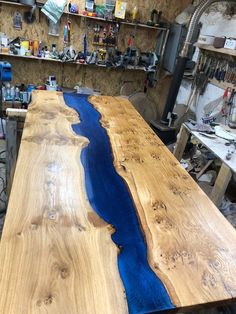 a table made out of wood with blue paint on it in a workshop area next to other workbench and tools