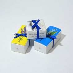 three small boxes with blue and yellow ribbons