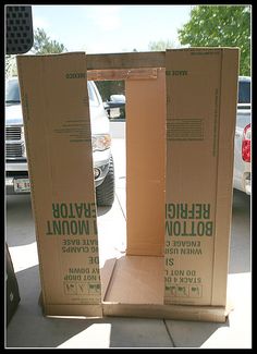 two cardboard boxes sitting on the ground in front of a car