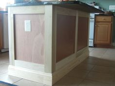 a kitchen island made out of plywood is shown in the middle of a tile floor