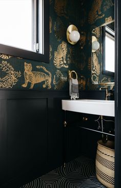 the bathroom is decorated in black and gold with tiger wallpapers on the walls