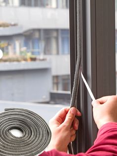 a person is opening a window with a large piece of tape on the outside of it