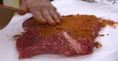 a person cutting up some meat on top of a white paper towel with seasoning