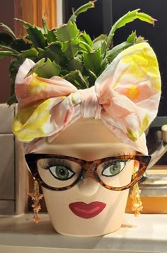 a mannequin head with glasses and a bow on it's head is shown in front of a mirror