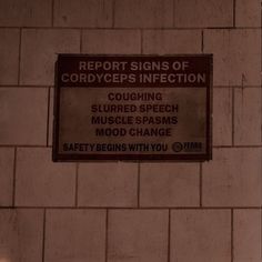 a sign that is on the side of a brick wall reading report signs of corrodypes infection