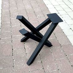 a black bench sitting on top of a brick walkway next to a sidewalk with white bricks