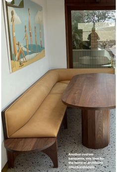 a wooden bench sitting in front of a window next to a painting on the wall