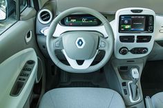 the interior of a small car with dashboard controls and steering wheel, including an electronic display