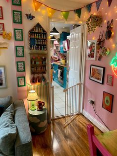 a living room filled with furniture and lots of pictures hanging on the wall above it