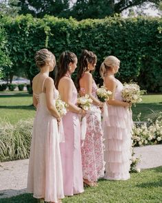 a group of women standing next to each other on top of a lush green field