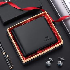 an open box with two cufflinks and a pair of earrings in it next to a pen