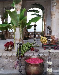 there are many different types of fruits and vegetables on the table in front of this building