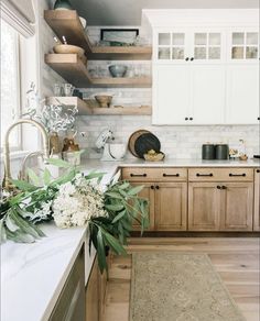 a kitchen with wooden cabinets and white marble counter tops